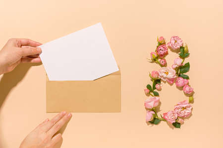 International Women's Day. Flower composition 8. Creative date. Heads of delicate roses on a light pastel beige background. Mockup postcard Mother's Day, March 8. Spring flower background, copy spaceの写真素材
