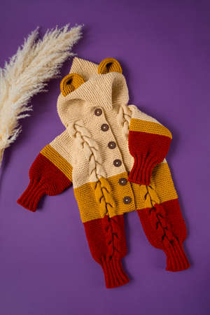 Knitted clothes color background. Handmade children's clothing. Knitted suit top view flat composition. The concept of hobby, individual marketing, entrepreneurship. Autumn time is cozy and warm.の写真素材