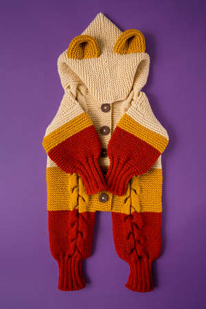 Knitted clothes color background. Handmade children's clothing. Knitted suit top view flat composition. The concept of hobby, individual marketing, entrepreneurship. Autumn time is cozy and warm.の写真素材