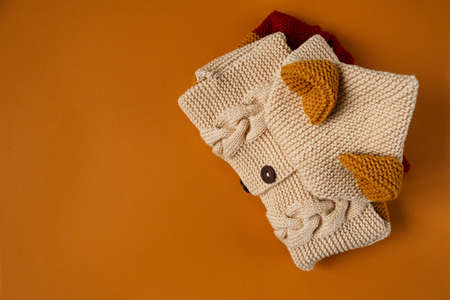 Knitted clothes color background. Handmade children's clothing. Knitted suit close-up stacked. The concept of hobby, individual marketing, entrepreneurship. Autumn is a time of comfort and warmth.の写真素材