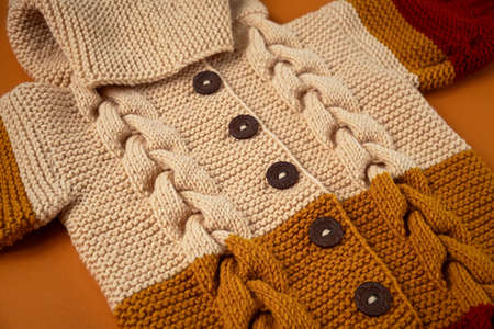 Knitted clothes color background. Handmade children's clothing. Knitted suit close-up view from above. The concept of hobby, individual marketing, entrepreneurship. Autumn time is cozy and warm.の写真素材