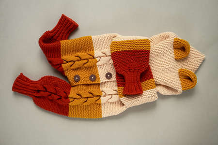 Knitted clothes color background. Handmade children's clothing. Knitted suit top view flat composition. The concept of hobby, individual marketing, entrepreneurship. Autumn time is cozy and warm.の写真素材