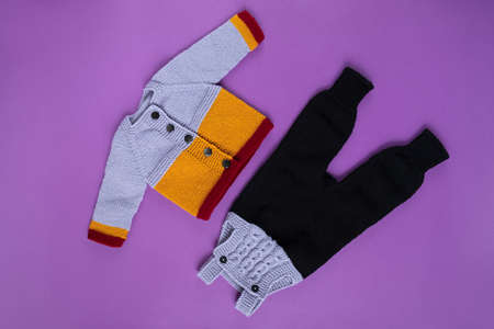 Knitted clothes color background. Handmade children's clothing. Knitted suit top view flat composition. The concept of hobby, individual marketing, entrepreneurship. Autumn time is cozy and warm.の写真素材