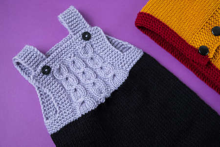 Knitted clothes color background. Handmade children's clothing. Knitted suit top view flat composition. The concept of hobby, individual marketing, entrepreneurship. Autumn time is cozy and warm.の写真素材