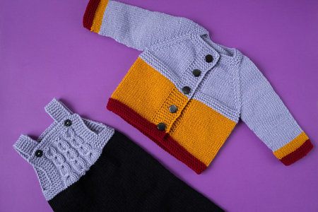 Knitted clothes color background. Handmade children's clothing. Knitted suit top view flat composition. The concept of hobby, individual marketing, entrepreneurship. Autumn time is cozy and warm.の写真素材