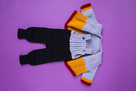 Knitted clothes color background. Handmade children's clothing. Knitted suit top view flat composition. The concept of hobby, individual marketing, entrepreneurship. Autumn time is cozy and warm.の写真素材