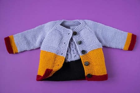 Knitted clothes color background. Handmade children's clothing. Knitted suit top view flat composition. The concept of hobby, individual marketing, entrepreneurship. Autumn time is cozy and warm.の写真素材