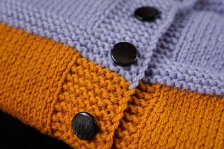 Knitted clothes color background. Handmade children's clothing. Knitted suit close-up view from above. The concept of hobby, individual marketing, entrepreneurship. Autumn time is cozy and warm.の写真素材
