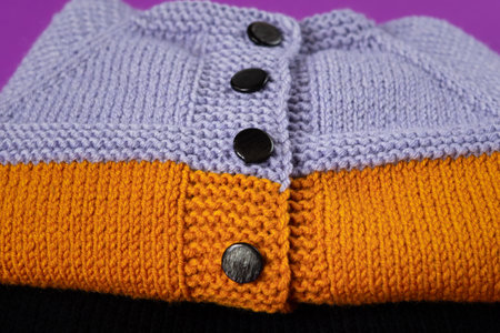 Knitted clothes color background. Handmade children's clothing. Knitted suit close-up view from above. The concept of hobby, individual marketing, entrepreneurship. Autumn time is cozy and warm.の写真素材