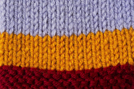 Knitted texture background. Hand-knitted wool. Macrophotography of a thread drawing. Striped bright texture of sweaters pullovers cardigans. Abstract natural background. Comfort autumn warmth conceptの写真素材