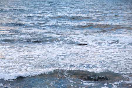 Pastel-gray sea. texture of a raging ocean, full frame with space for text. The concept of weather, vacation, travel. The purest clear sea water, big waves close-up. Calm natural light gray backgroundの写真素材