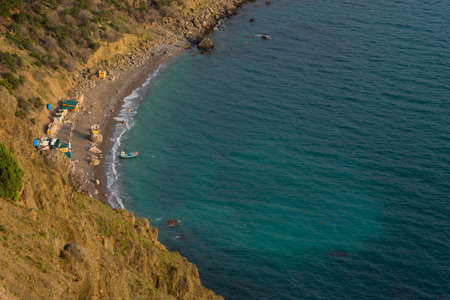 Beautiful landscape blue turquoise sea. Top view of the deserted beach from the mountain. The concept of summer, vacation, travel and outdoor activities. Small boats moored on the shore. warm lightの写真素材
