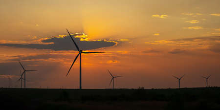 Wind turbines at sunset. Wind turbines in the orange sky. Rural areas with renewable energy sources. The concept of environmental safety green energy. Landscape with windmills. Sustainable developmentの写真素材