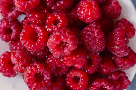 Raspberry macro background. The texture is food. Ripe raspberries in close-up. The concept of summer food, freshness, vitamins. Beautiful berries in a selective focus. Summer dietary healthy dessert.の写真素材