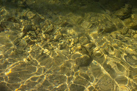 Water mountain river texture. Full frame. Fashionable light beige iridescent color of pure water....