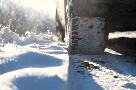 Car wheels snow close-up. Driving on a winter road. Winter tires shooting from a lower angle. The...