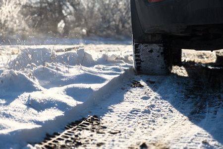 Car wheels snow close-up. Driving on a winter road. Winter tires shooting from a lower angle. The...