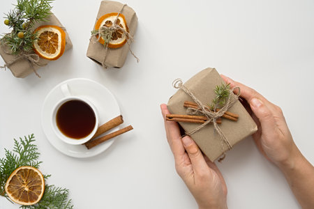 Zero waste christmas concept. Natural gift materials paper fir branches dried citrus cinnamon on a white background. A gift in women's hands. Eco-greeting card in pastel colors. Gifts New Year 2023の写真素材