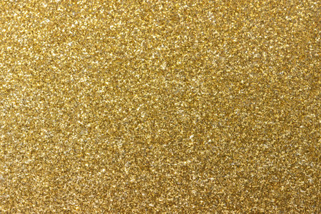 Golden shiny background. New Year's bright yellow-gold abstract background for design. The concept of celebration, fun, glamour and luxury. Sparkling in the sun. Decoration of wrapping paper,fabric.の写真素材