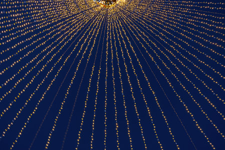 Abstraction blurred movement lights garlands. Golden lights of a blurred garland on the background of a purple blue sky. The concept of a night holiday night. Designer background of the New Year.の写真素材