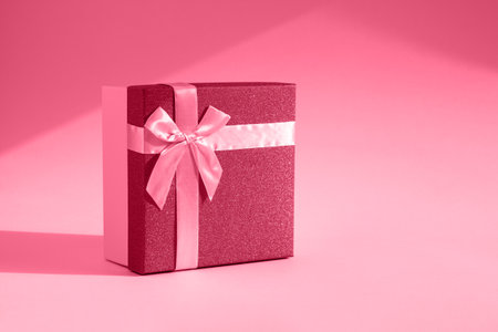 Viva magenta gift. The fashionable trending color of 2023. Tinted image of a gift box on a paper background. The concept of a holiday, birthday, Valentine's Day. Sensual romantic color in bright lightの写真素材