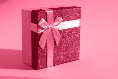 Viva magenta gift. The fashionable trending color of 2023. Tinted image of a gift box on a paper background. The concept of a holiday, birthday, Valentine's Day. Sensual romantic color in bright lightの写真素材