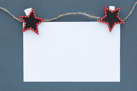 Mockup. A white sheet of notepad on a gray background. A sheet on clothespins and a rope. Conceptual business minimalism. The concept of advertising, monochrome design, stylish Christmas bannerの写真素材