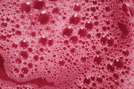 Pink foam texture. Viva magenta abstract background. The trending color of 2023. Macrophotography of shampoo soap bubbles. Layout for the design of cosmetic brochures. Tinted image Fashionable textureの写真素材