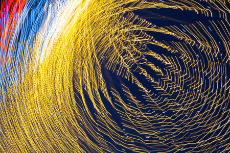 Abstraction blurred movement lights garlands. Golden lights of a blurred garland on the background of a purple blue sky. The concept of a night holiday night. Designer background of the New Year.の写真素材