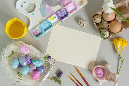 Easter egg coloring composition. Top view of a still life of paints, palettes, brushes, flowers. Easter preparation for the holiday. The concept of manual creativity, creative ideas. Copy spaceの写真素材