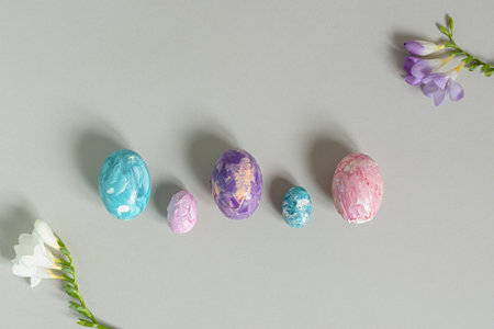 Happy Easter. Easter multicolored eggs on a light gray background. Greeting card, horizontal banner with copy space, top view. Creative Easter composition in pastel colors, flat lay. Handmade, designの写真素材