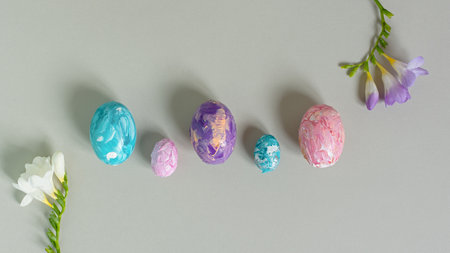 Happy Easter. Easter multicolored eggs on a light gray background. Greeting card, horizontal banner with copy space, top view. Creative Easter composition in pastel colors, flat lay. Handmade, designの写真素材