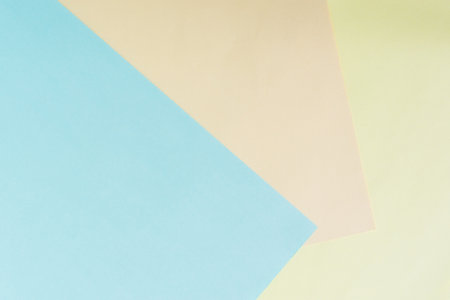 Paper colored pastel background. Light beige, blue, yellow in geometric composition top view....