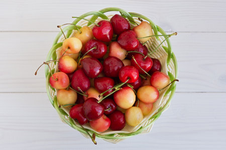 Cherries in a basket on the table. Ripe sweet delicious cherries in a wicker basket. Summer berries close-up. Vegetarian food, healthy fruits from the garden, rich in vitamins. Harvesting by farmersの写真素材