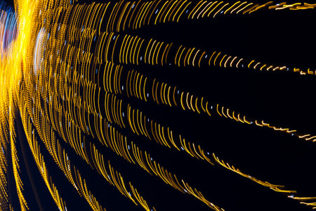 Abstraction blurred movement lights garlands. Golden lights of a blurred garland on the background of a purple blue sky. The concept of a night holiday night. Designer background of the New Year.の写真素材