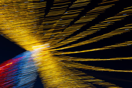Abstraction blurred movement lights garlands. Golden lights of a blurred garland on the background of a purple blue sky. The concept of a night holiday night. Designer background of the New Year.の写真素材