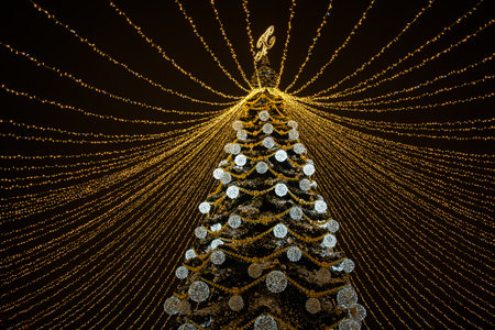 Christmas tree street. A bright decorated Christmas tree with golden garlands and balloons on the background of the night sky. The concept of a holiday New Year Christmas. Abstract postcard backgroundの写真素材