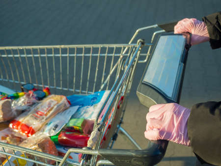 Woman with food supplies in trolleyの写真素材