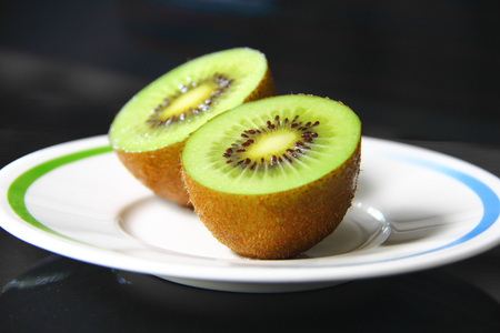 Fresh kiwi fruit cut in a half on dish.の写真素材