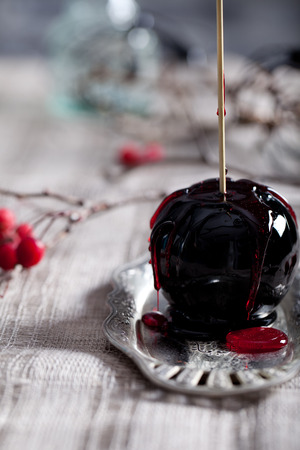 Halloween black and red caramelized apples on a wooden sticks. Traditional dessert. Selective focus.の写真素材
