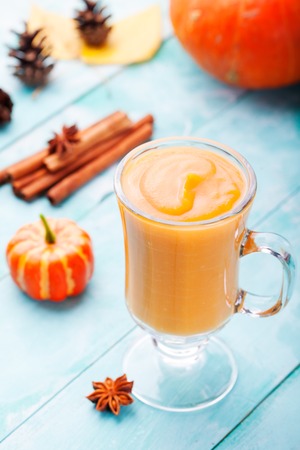Pumpkin smoothie with pumpkin pie spices spices on a turquoise wooden backgroundの写真素材