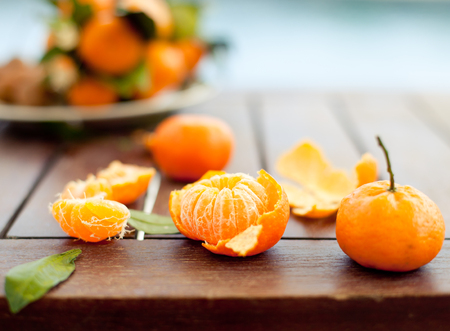 Fresh tangerines on a wooden table on a blue sea water backgroundの写真素材