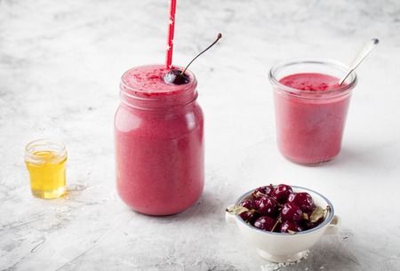 Cherry coconut milk, yogurt and honey smoothie on a stone backgroundの写真素材