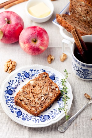 Apple, walnut cake, loaf, bread with fresh apples and cinnamon sticks on a textile blue and white background.の写真素材
