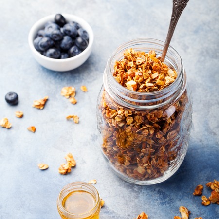 Healthy breakfast. Fresh granola, muesli with berries, honey in a glass jarの写真素材