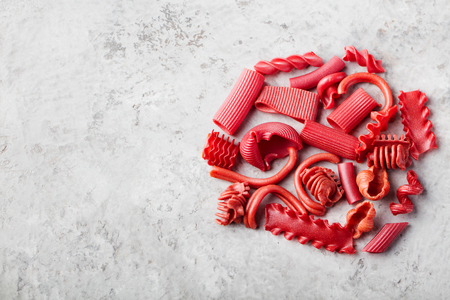 Pile of naturally colored red pasta with beetroot Stone background Copy spaceの写真素材
