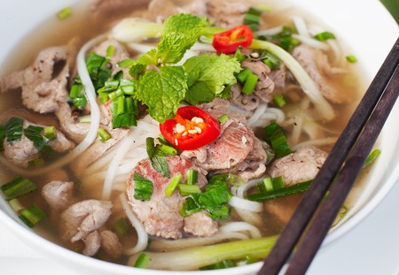 Traditional Vietnamese beef soup pho on a wooden background