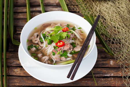Traditional Vietnamese beef soup pho on a wooden backgroundの写真素材
