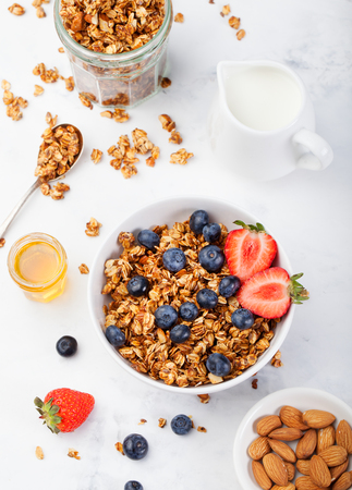 Healthy breakfast Fresh granola, muesli in bowl with milk and berries on a white background Top viewの写真素材