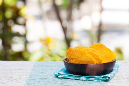 Dehydrated dried mango in wooden bowl Healthy snack Copy spaceの写真素材